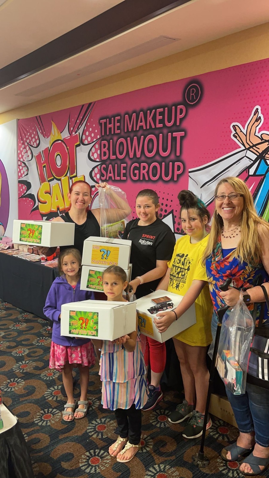 Family of customers stacking mystery boxes