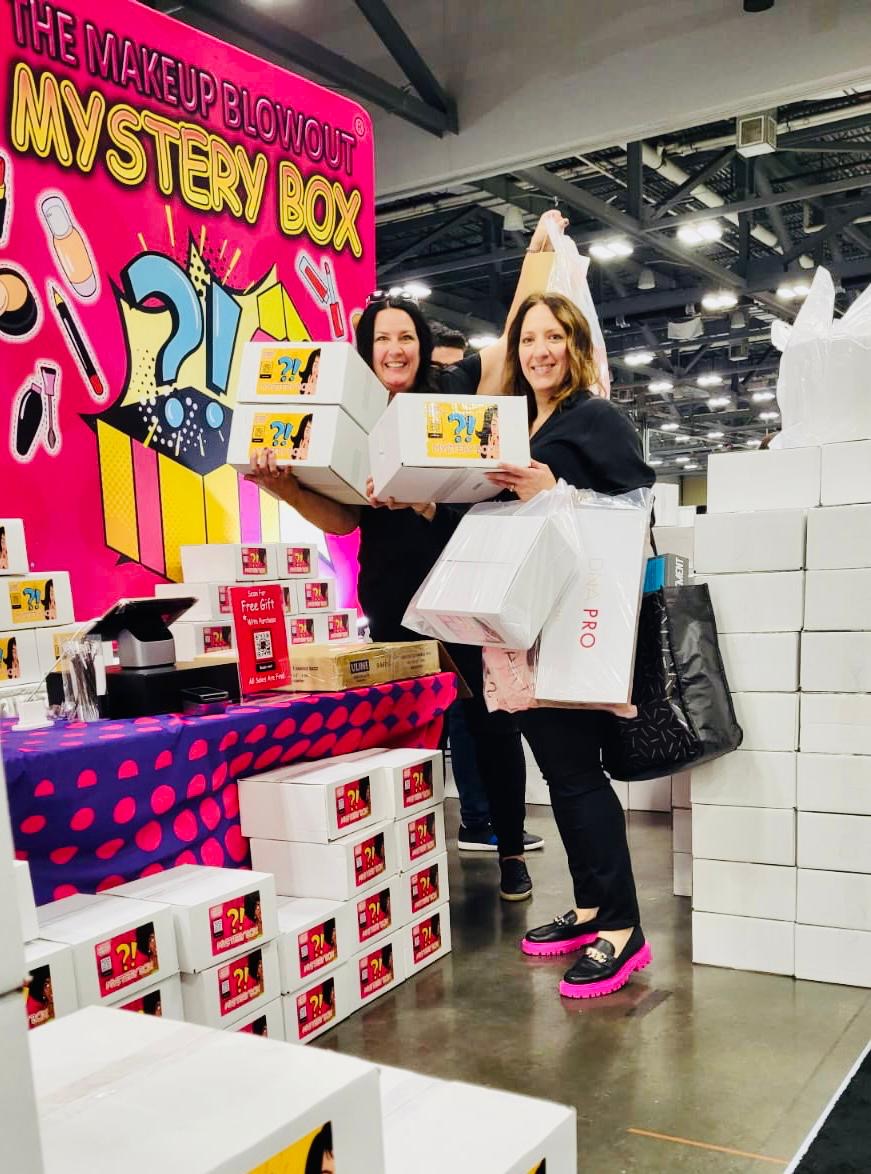 Two customers carrying armfuls of mystery boxes