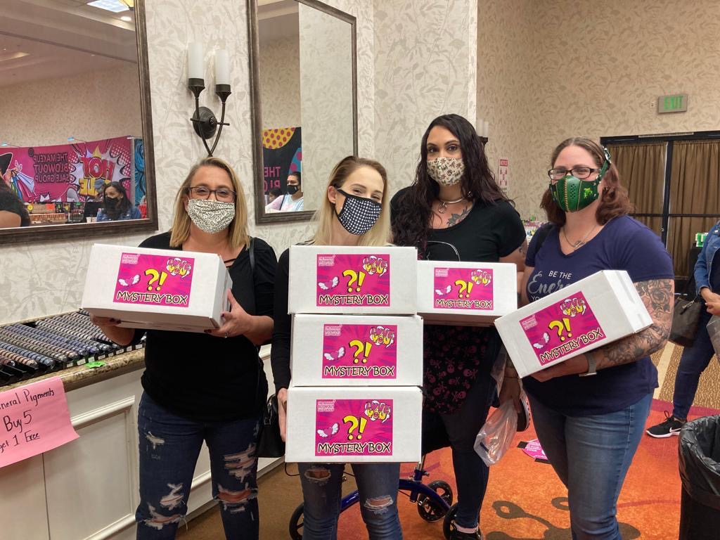 Four customers holding mystery boxes together